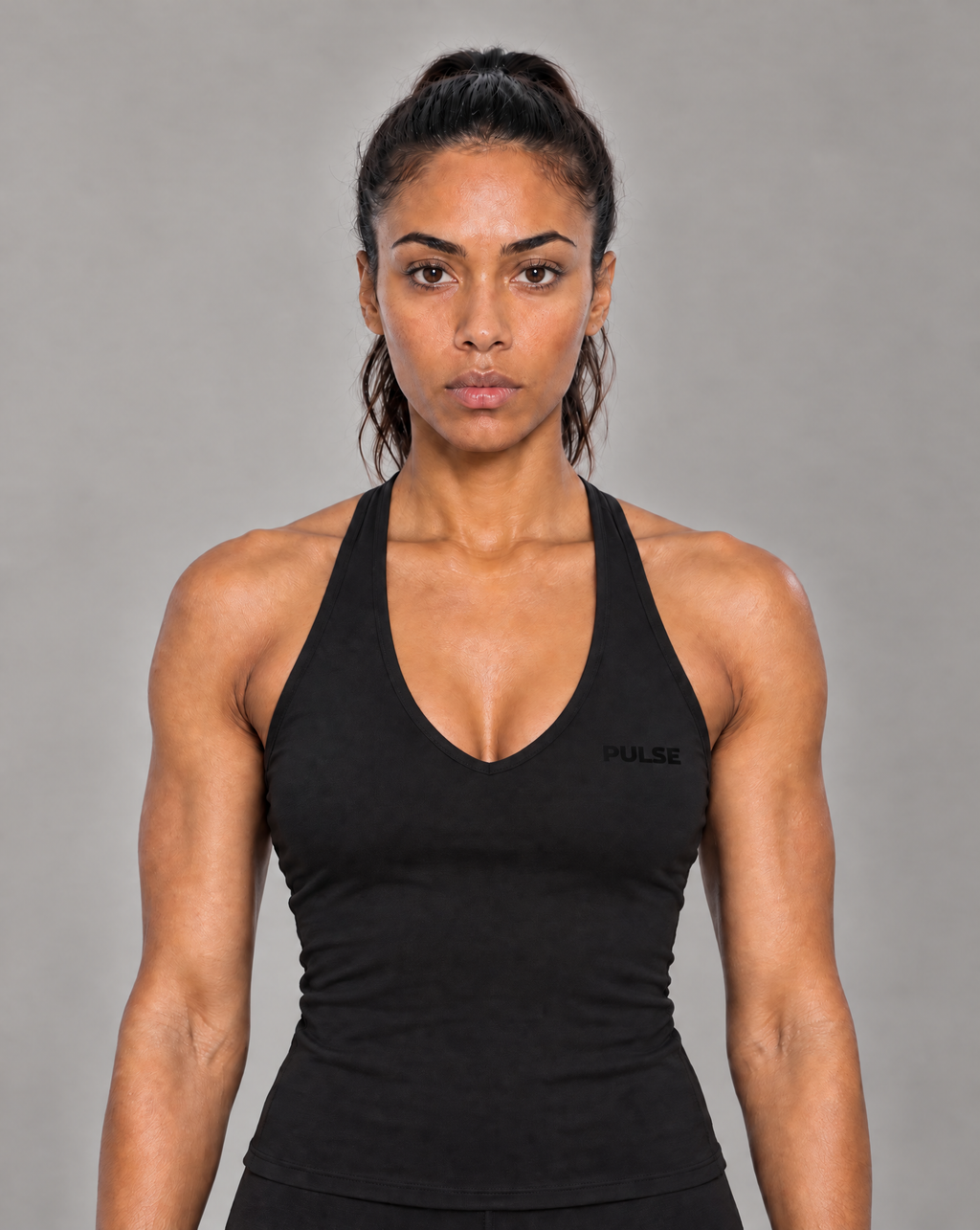 Model trägt schwarzes PULSE Spectre Halter Tanktop mit dezentem schwarzem Brustlogo.